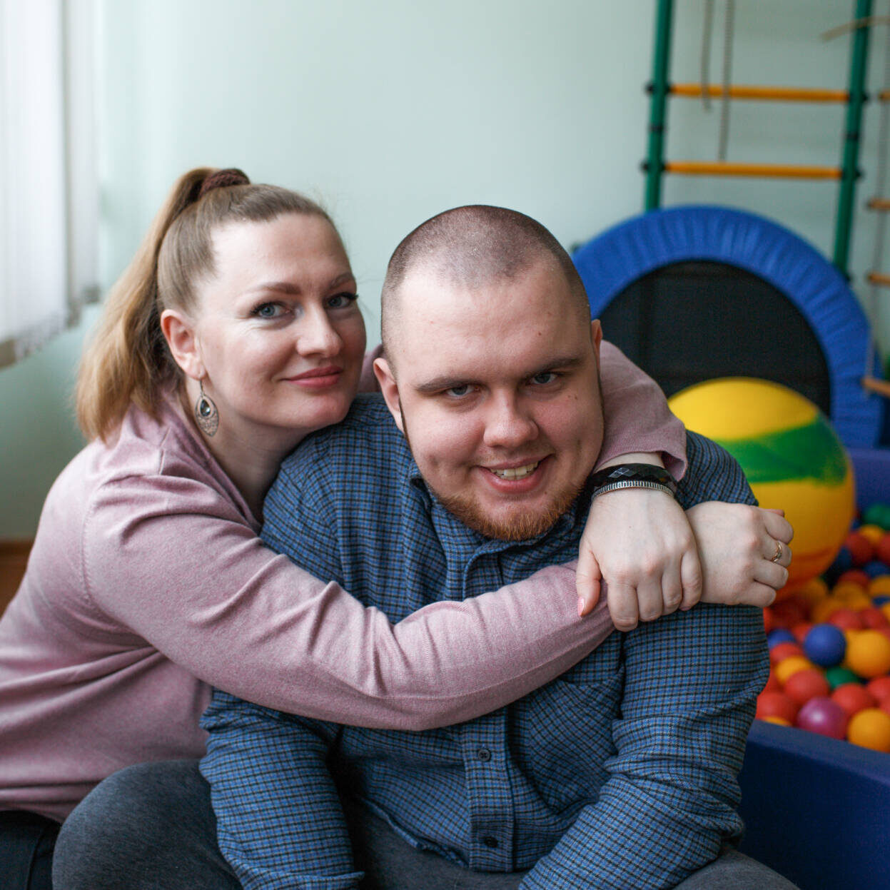 caring mom hugs a child diagnosed with autism in a rehabilitation center
